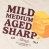 Close-up of Sargento Cheddar Lineup Tee back graphic with cheddar block and Mild, Medium, Aged, Sharp text