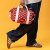 Sargento Cheeseburger Cooler Bag carried by hand, showing red cheeseburger pattern and white straps