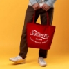 Sargento Heritage Tote Bag carried by hand, showing red tote design with white Sargento logo and “Family-Backed Quality” text