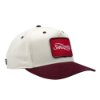 Two-tone view of "The Heritage Snapback", showing a cream crown, burgundy brim, and red front patch logo.