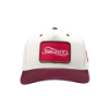 Front view of "The Heritage Snapback", showing a centered red patch logo and structured cream panels.